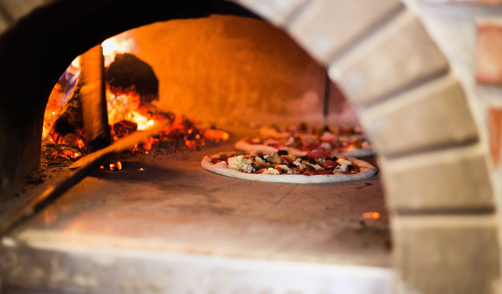 Flammes dans un four à pizza traditionnel alimenté au bois